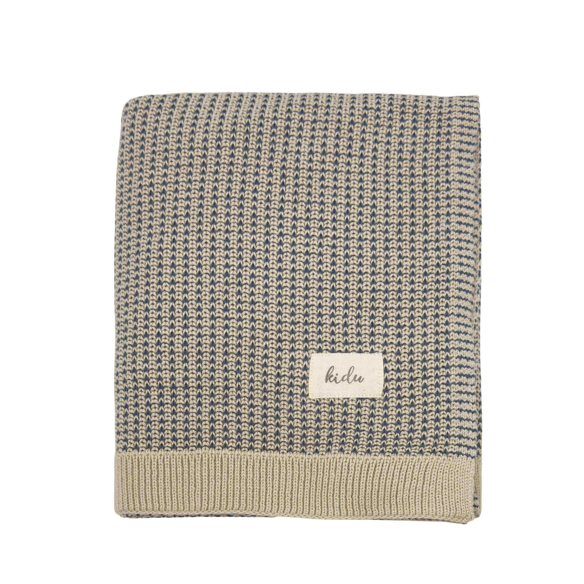 Textured knitted blanket with a kidu brand label on a white background